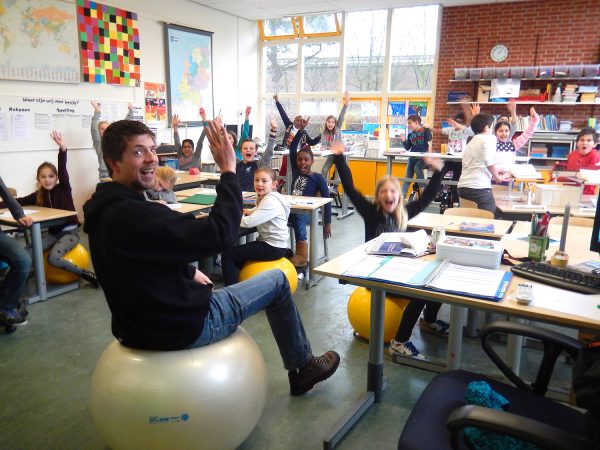 Übungsleiter und Schüler auf Sit-up-Bällen